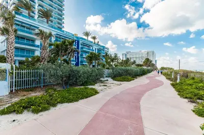 a sidewalk in front of a building with palm trees at Monte Carlo Miami Beach in Miami Beach