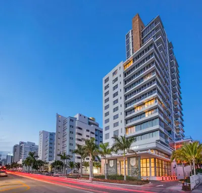 a tall building with palm trees in front of a street at Monte Carlo Miami Beach in Miami Beach