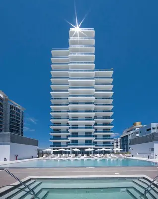 a tall building with a pool in front of it at Monte Carlo Miami Beach in Miami Beach