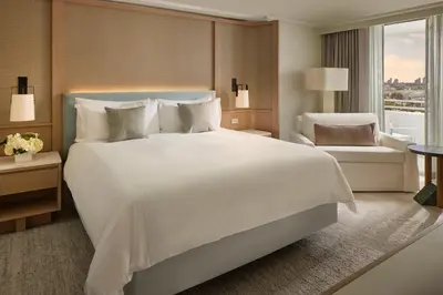 a bedroom with a large white bed and a chair at Loews Miami Beach Hotel in Miami Beach