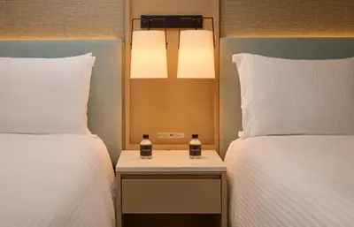a hotel room with two beds and a nightstand between them at Loews Miami Beach Hotel in Miami Beach