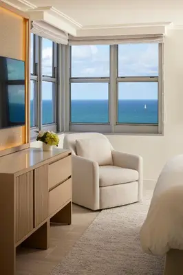 a bedroom with a bed and a desk and a chair at Loews Miami Beach Hotel in Miami Beach