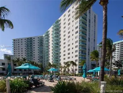 a large building with a beach with chairs and umbrellas at The Tides Miami in Miami