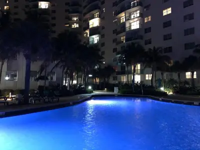 a large swimming pool in front of a building at night at The Tides Miami in Miami