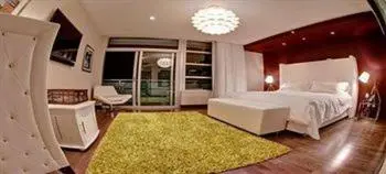 a bedroom with a large bed and a green rug at Prime Hotel Miami in Miami Beach