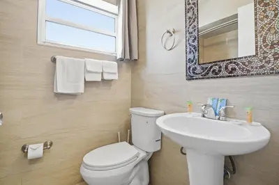 a bathroom with a toilet and a sink and a mirror at La Terrace Oceanfront in Hollywood