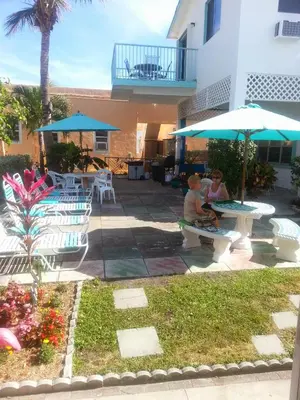 two people sitting on a bench under an umbrella at Atlantic Sands Beach Suites in Hollywood
