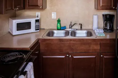 a kitchen with a sink and a microwave at Riptide Oceanfront Hotel in Hollywood
