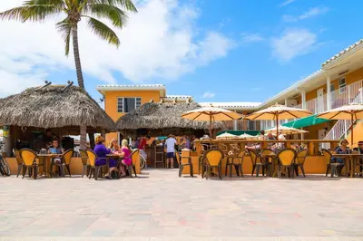 a group of people sitting at tables with umbrellas at Riptide Oceanfront Hotel in Hollywood