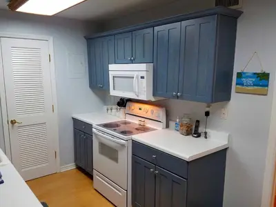 a kitchen with blue cabinets and a white microwave at Large Lush Oasis Paradise by FLL Beach and Galleria - 2bd 2ba in Fort Lauderdale