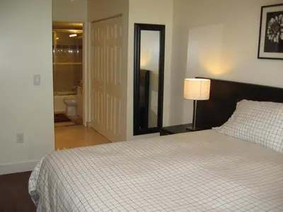 a bedroom with a bed and a lamp and a bathroom at Resort Style In Aventura Florida in Aventura
