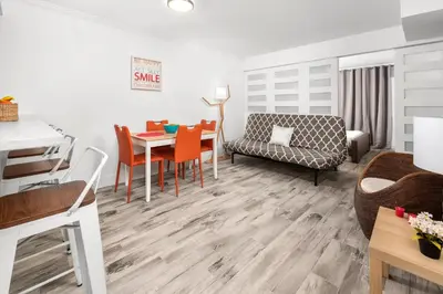 a living room with a table and a couch at SoBe Lux Suites On Ocean in Miami Beach