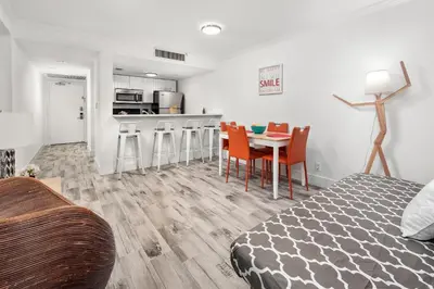a room with a bed and a table and chairs at SoBe Lux Suites On Ocean in Miami Beach