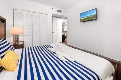 a bedroom with a bed with blue and white stripes at SoBe Lux Suites On Ocean in Miami Beach