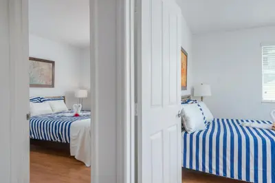 a bedroom with two beds with blue and white stripes at SoBe Lux Suites On Ocean in Miami Beach