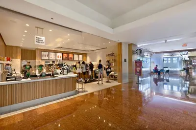 a shopping mall with people walking around a store at StayCozy Apartments at The Grand in Miami