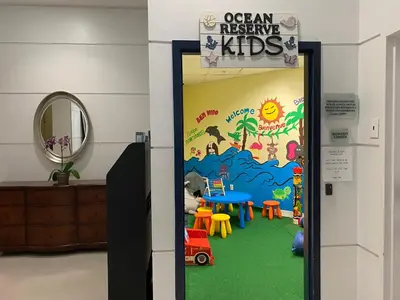an open door to a play room with a sign that reads ocean rescue kids at Sunny Isles Condo Resort in Miami Beach