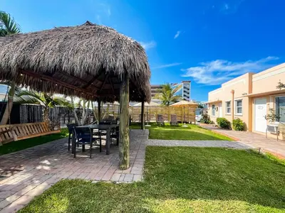a patio with a table and a straw umbrella at The Flamingo in Hollywood