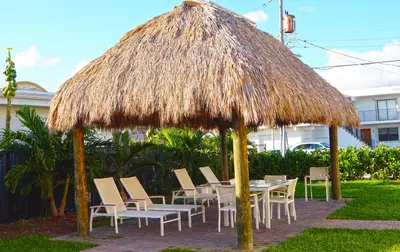 a table and chairs under a straw umbrella at The Flamingo in Hollywood