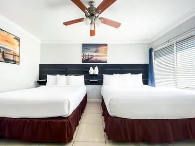 two beds in a room with a ceiling fan at The Flamingo in Hollywood