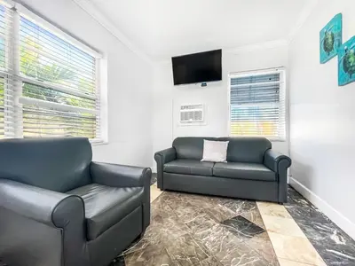 a living room with two couches and a flat screen tv at The Blue Wave in Hollywood