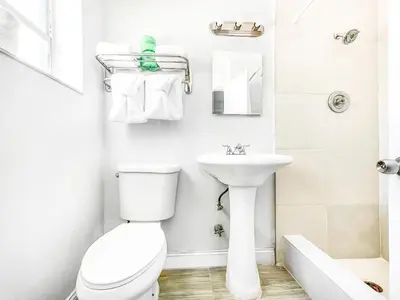 a white bathroom with a toilet and a sink at The Blue Wave in Hollywood