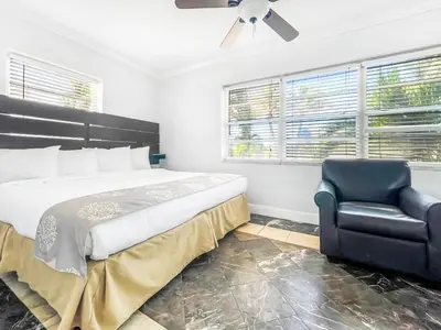 a bedroom with a bed and a black chair at The Blue Wave in Hollywood