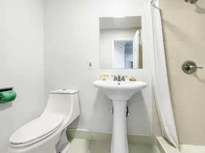 a white bathroom with a toilet and a sink at The Seagull in Hollywood