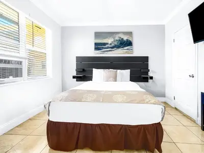 a bedroom with a large bed with a black headboard at Hollywood Beach Seaside in Hollywood