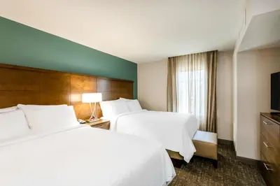 a hotel room with two beds and a television at Staybridge Suites - Fort Lauderdale Airport - West by IHG in Davie