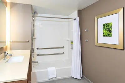 a bathroom with a shower and a white tub at Staybridge Suites - Fort Lauderdale Airport - West by IHG in Davie