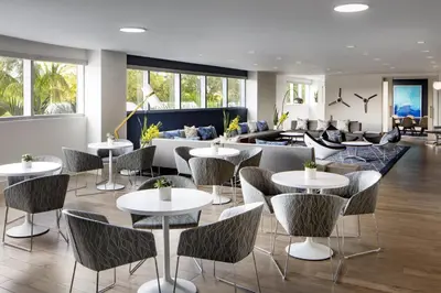 a restaurant with tables and chairs and a couch at Le Meridien Dania Beach at Fort Lauderdale Airport in Dania Beach