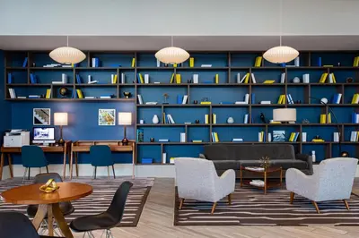 a living room with a blue wall with shelves at Le Meridien Dania Beach at Fort Lauderdale Airport in Dania Beach
