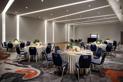 a conference room with tables and chairs and a screen at Le Meridien Dania Beach at Fort Lauderdale Airport in Dania Beach