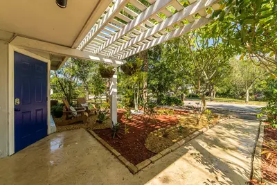 a patio with a white pergola on a house at The Blue Door Inn in Fort Lauderdale