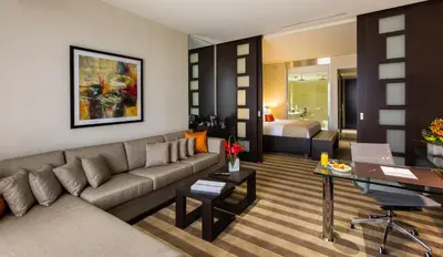a living room with a couch and a bedroom at EB Hotel Miami Airport in Miami