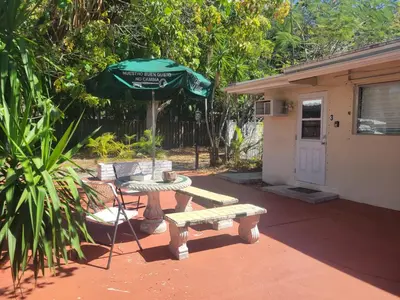 a patio with a picnic table and an umbrella at Apts with Backyard Near Fort Lauderdale Beach, Nightlife, Cruise Port, Airport in Fort Lauderdale