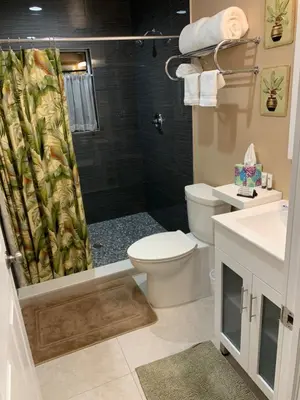 a bathroom with a toilet and a shower curtain at Fantasy Island Inn, Caters to Men in Fort Lauderdale