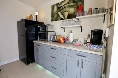 a kitchen with a black refrigerator and a counter top at Fantasy Island Inn, Caters to Men in Fort Lauderdale