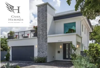 a large white house with a garage at CASA HERMÈS Wilton Manor - Gay Guesthouse in Fort Lauderdale