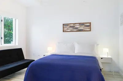 a bedroom with a blue bed and a couch at Amazing 2 BR Condo At Wynwood With Parking in Miami