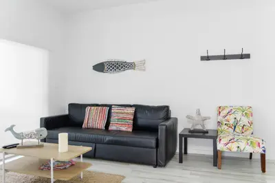 a living room with a black couch and a chair at Amazing 2 BR Condo At Wynwood With Parking in Miami