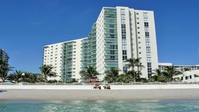 a large building on the beach in front of a building at The Tides Apartments on the beach in Hollywood