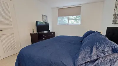 a bedroom with a blue bed and a television at The Tides Apartments on the beach in Hollywood