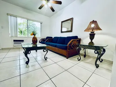 a living room with a blue couch and two tables at Beach Tide Motel in Hollywood