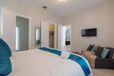 a bedroom with a large white bed and a couch at Modern villa w lake view heated pool grill in Hollywood