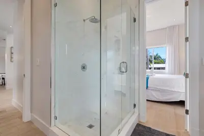 a glass shower in a room with a bedroom at Modern villa w lake view heated pool grill in Hollywood