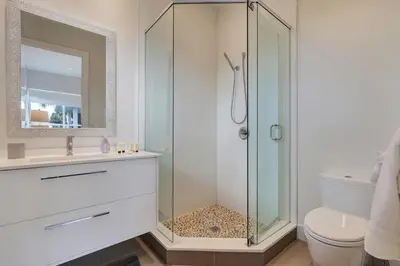 a bathroom with a glass shower and a toilet at Modern villa w lake view heated pool grill in Hollywood