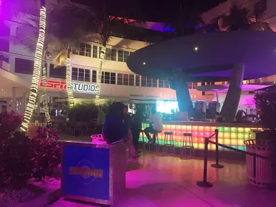 a person sitting at a bar in front of a building at Heart of South Beach / Modern Apartment / Ocean Drive - Carlyle in Miami Beach