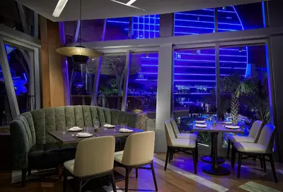a dining room with a table and chairs and blue lights at The Guitar Hotel at Seminole Hard Rock Hotel & Casino in Fort Lauderdale